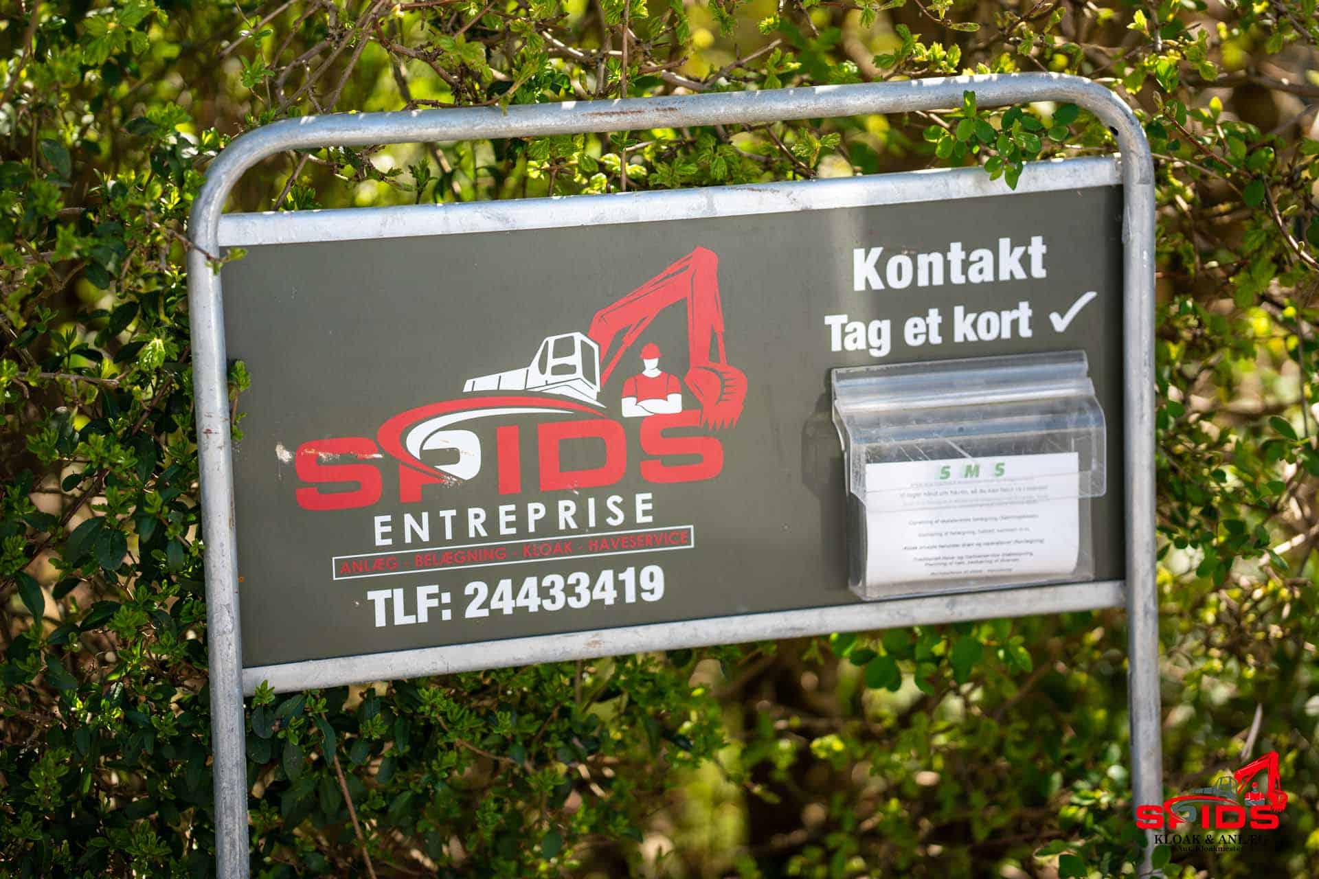 Skilt med Spids Kloak & Anlæg kontaktinformation og flyers til kontakt
